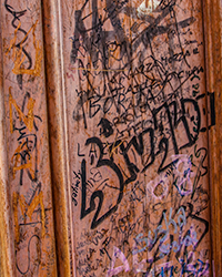 Against the weathered background of a stately Italian door, an alphabet soup of graffiti vibrates with energy.