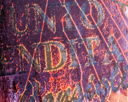 An weathered Italian sign forms a composition in mauves, violets, and lavenders.