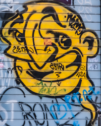A jokester genie rises from the metal surface of a Roman service door.