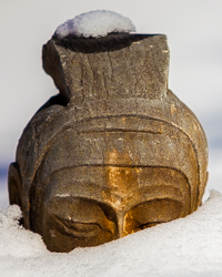 This carved stone statue of a Chinese soldier stands stoically in the snow.