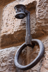 A sturdy iron bracket awaits a torch to light an Italian night street.